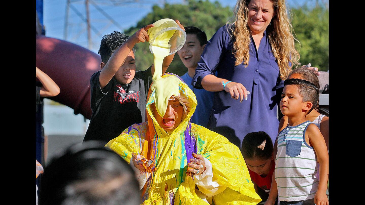 Fifth-grader Byron Benbow, 10, pours the last container of slime on the head of Principal Christina Desiderio at R.L. Stevenson Elementary School on Monday.