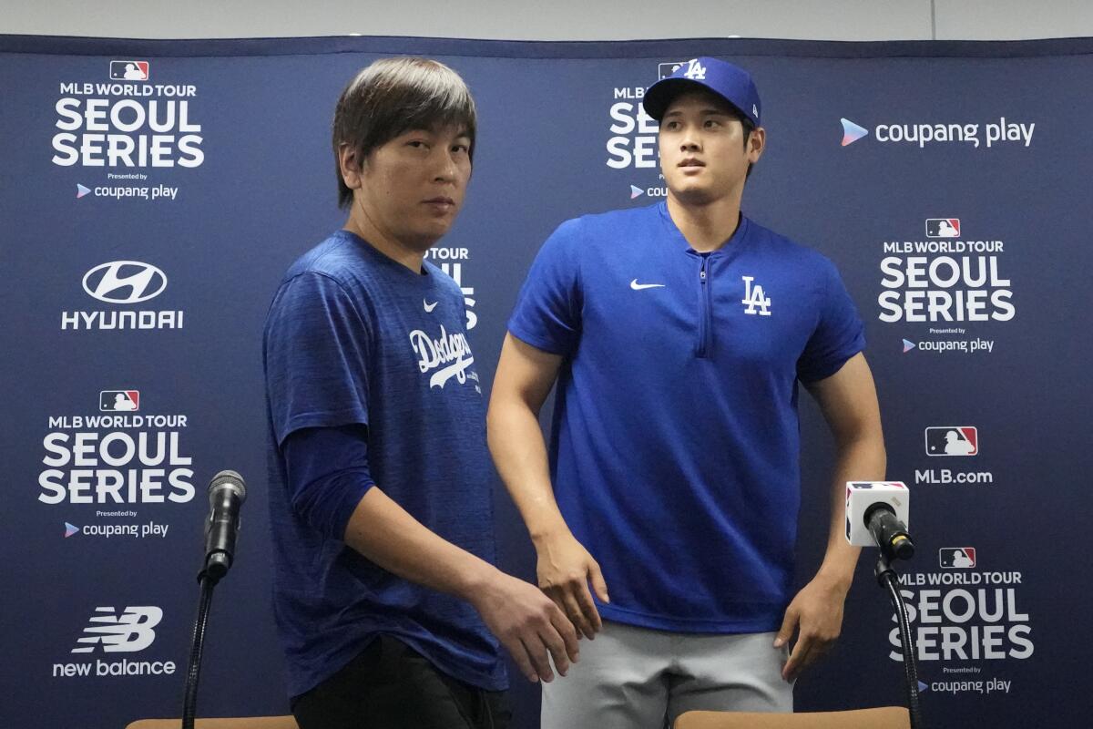 Dodgers star Shohei Ohtani, right, and his interpreter, Ippei Mizuhara, leave a news conference.