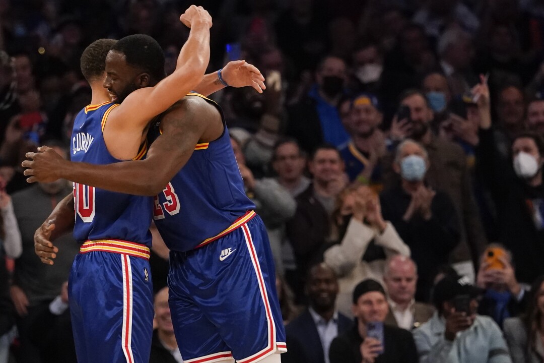 Golden State Warriors guard Stephen Curry hugs forward Draymond Green (23) after scoring a 3-point basket