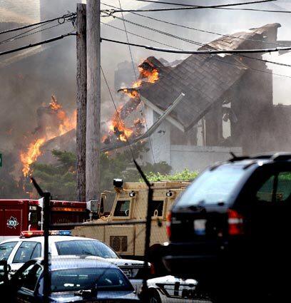 The roof collapses on a house in Maplewood, Mo., as it burns to the ground after police surrounded the house where a gunman was believed to be barricaded. Police and tactical units surrounded the house after the gunman fired shots at emergency workers, killing a St. Louis firefighter and wounding two others.