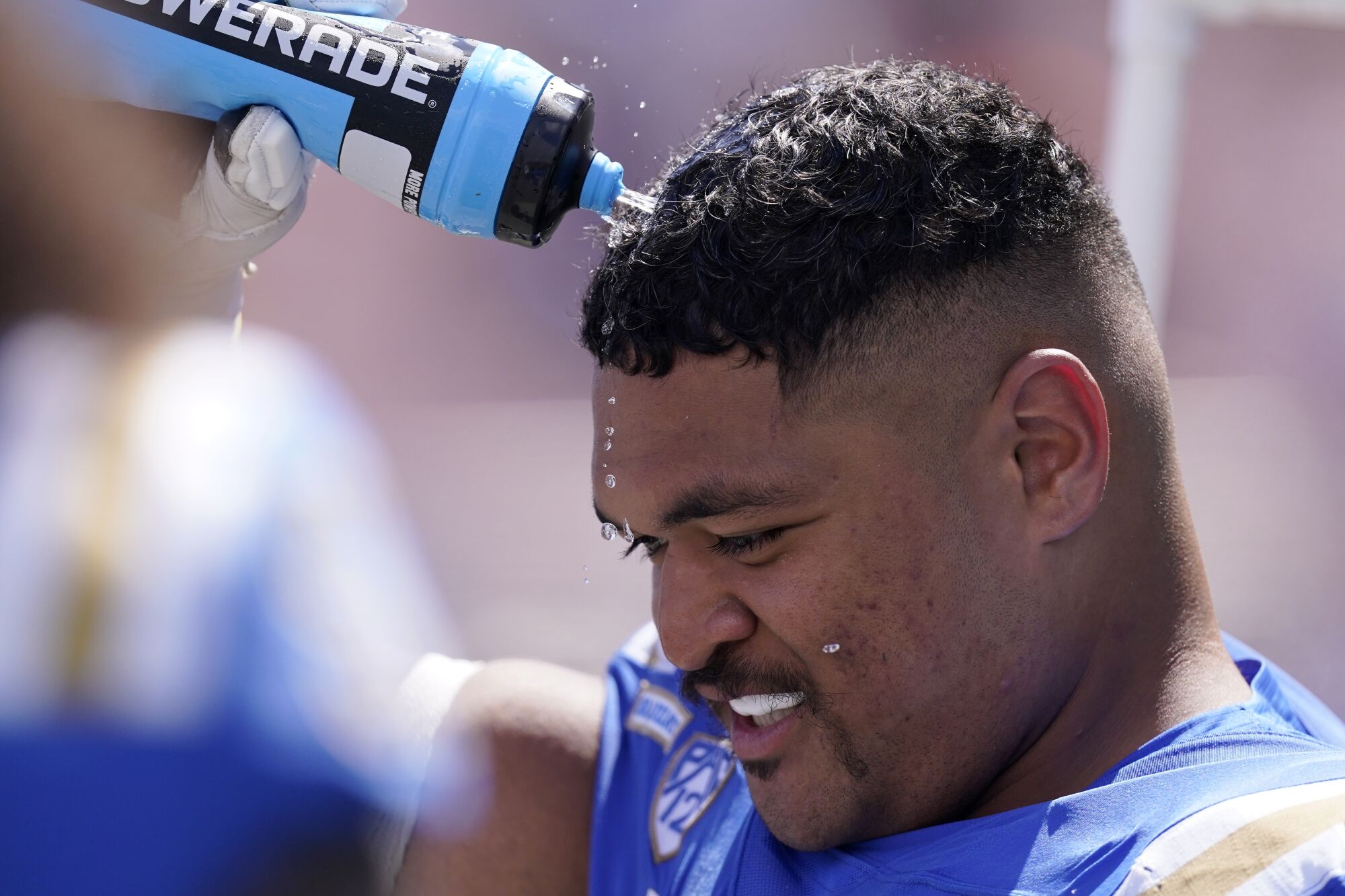 UCLA offensive lineman Atonio Mafi sprays water on his head during a game against Bowling Green