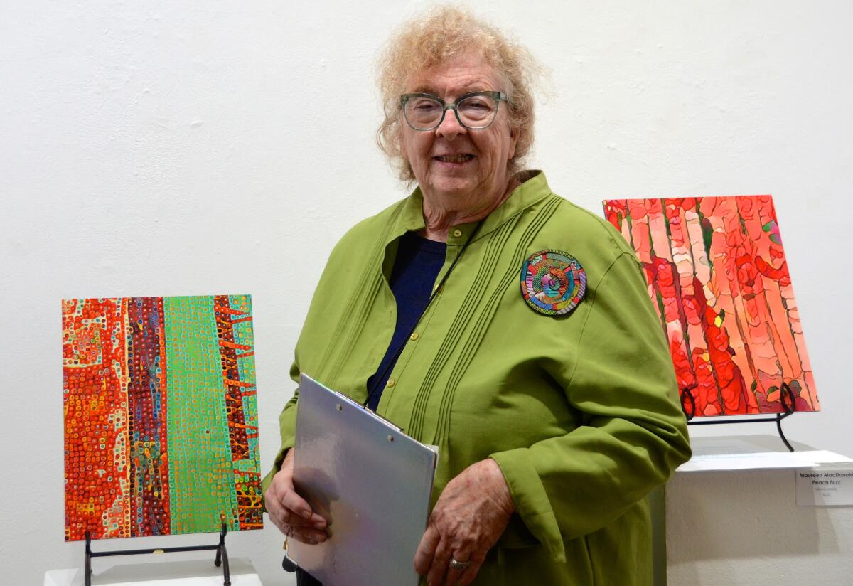 Showcase Gallery director Maureen MacDonald stands with her mixed-media pieces.