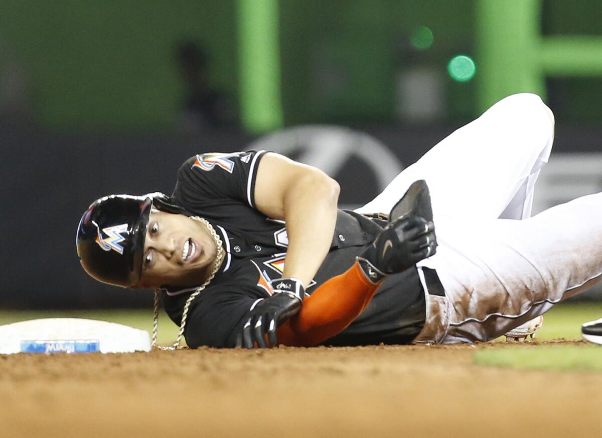 Marlins outfielder Giancarlo Stanton rolls over at second base after trying to stretch a single into a double in the ninth inning on Aug. 13.