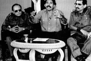 ARCHIVO - El exministro de Defensa Humberto Ortega, a la derecha, sentado junto a su hermano, el presidente Daniel Ortega, en el centro, y el ministro de Interior, Tomás Borge, en el anuncio de la expulsión de diplomáticos estadounidenses y del personal laboral y administrativo de la embajada de Estados Unidos en retaliación por un incidente en la sede diplomática de Nicaragua en Panamá, el 30 de diciembre de 1989. La policía nicaragüense informó el 21 de mayo de 2024 que Humberto Ortega estaba bajo vigilancia en su domicilio, alegando razones de salud, horas después de que concediera una controvertida entrevista. (AP Foto/Ernest Mejía, Archivo)
