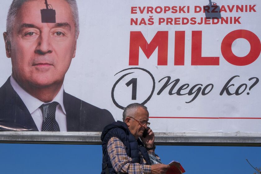 A man walks past a pre-election billboard showing pro-Western incumbent Milo Djukanovic, in Podgorica, Montenegro, Thursday, March 30, 2023. Voters in small Montenegro go to the polls this weekend to choose their next president in a runoff race between Milo Djukanovic and Jakov Milatovic. (AP Photo/Risto Bozovic)