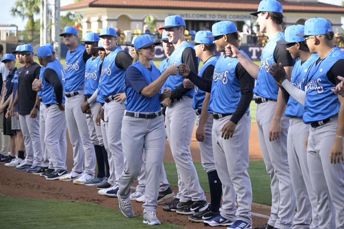 FILE - Tampa Tarpons manager Rachel Balkovec, center, exchanges fist bumps with her players, while making her debut as a minor league manager of the Tarpons, a Single-A affiliate of the New York Yankees, before a baseball game against the Lakeland Flying Tigers, Friday, April 8, 2022, in Lakeland, Fla. Players on the Single-A Tampa Tarpons have been talking individually about efforts to unionize minor league players and the idea is gaining momentum. (AP Photo/Phelan M. Ebenhack, File)
