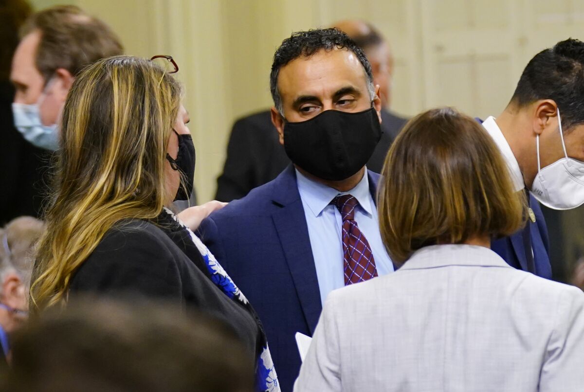 Assembly Member Ash Kalra talks with fellow members Tasha Boerner Horvath and Rebecca Bauer-Kahan.