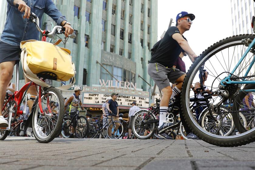 Bicyclists pass by the Wiltern.