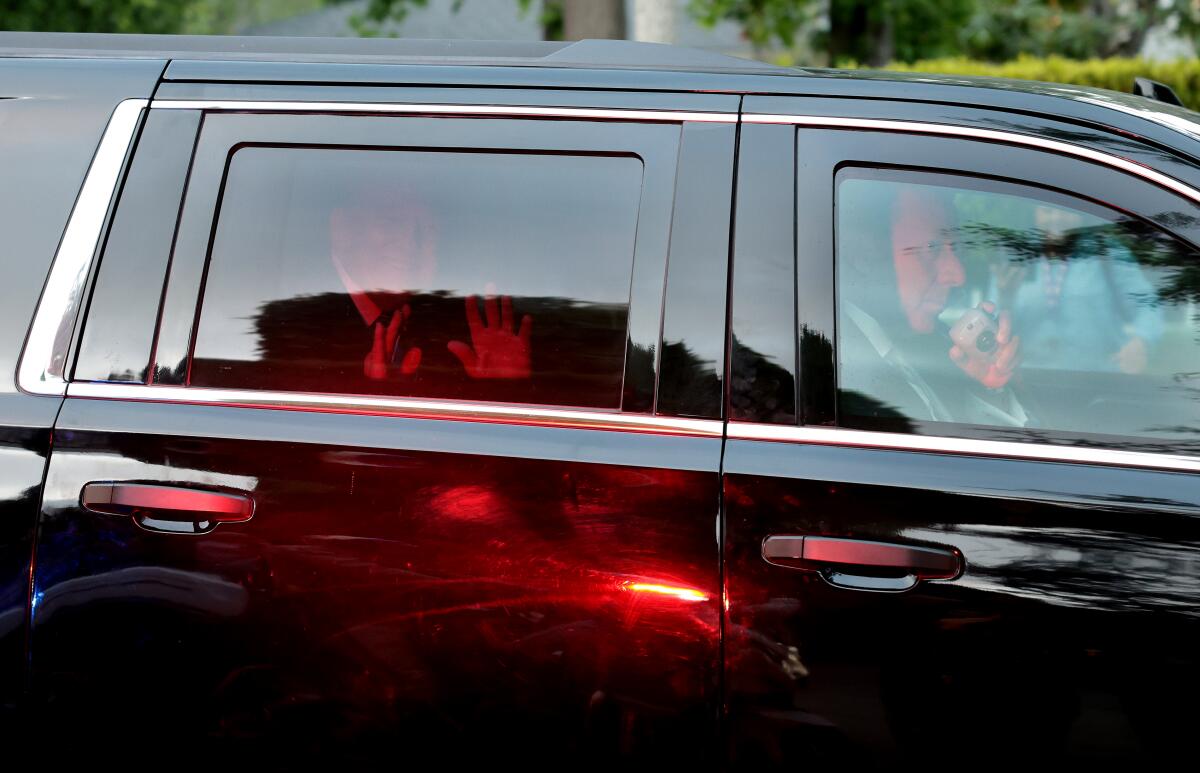 Donald Trump waves to fans as he leaves a home that held a fund raiser for his 