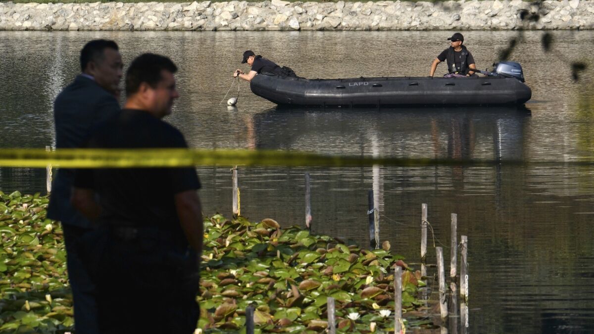 LAPD dive team members use sonar to search the bottom of Echo Park Lake near downtown Los Angeles on Thursday.