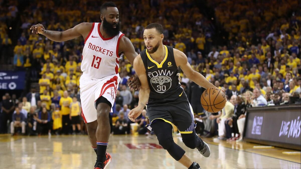 Golden State Warriors' Stephen Curry (30) drives with the ball against Houston Rockets' James Harden (13) during Game Four of the Western Conference finals on Tuesday.