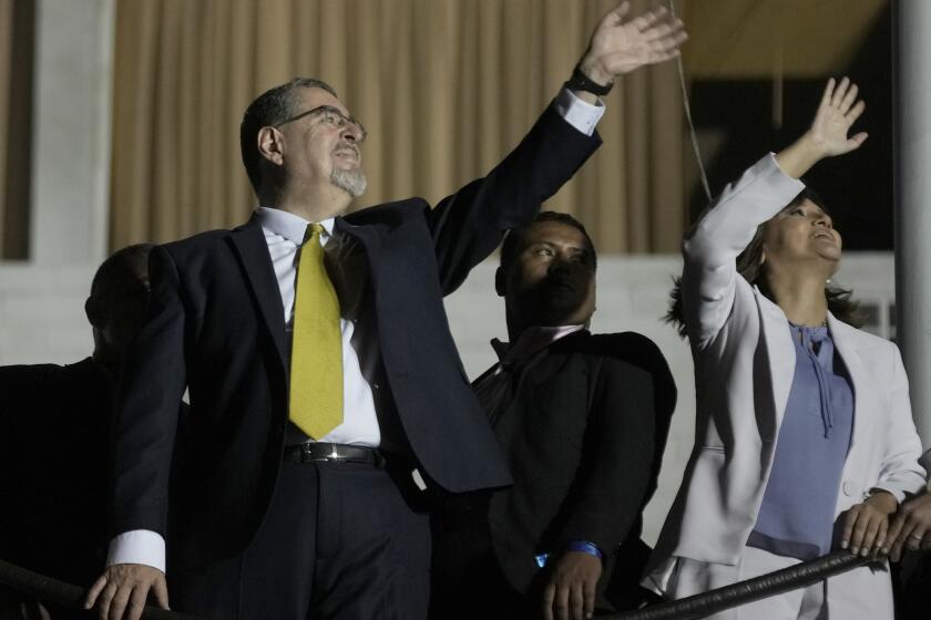 Presidential candidate Bernardo Arevalo and running mate Karin Herrera wave at supporters from a balcony after preliminary results showed him the victor in a presidential run-off election, in Guatemala City, Sunday, Aug. 20, 2023. (AP Photo/Moises Castillo)