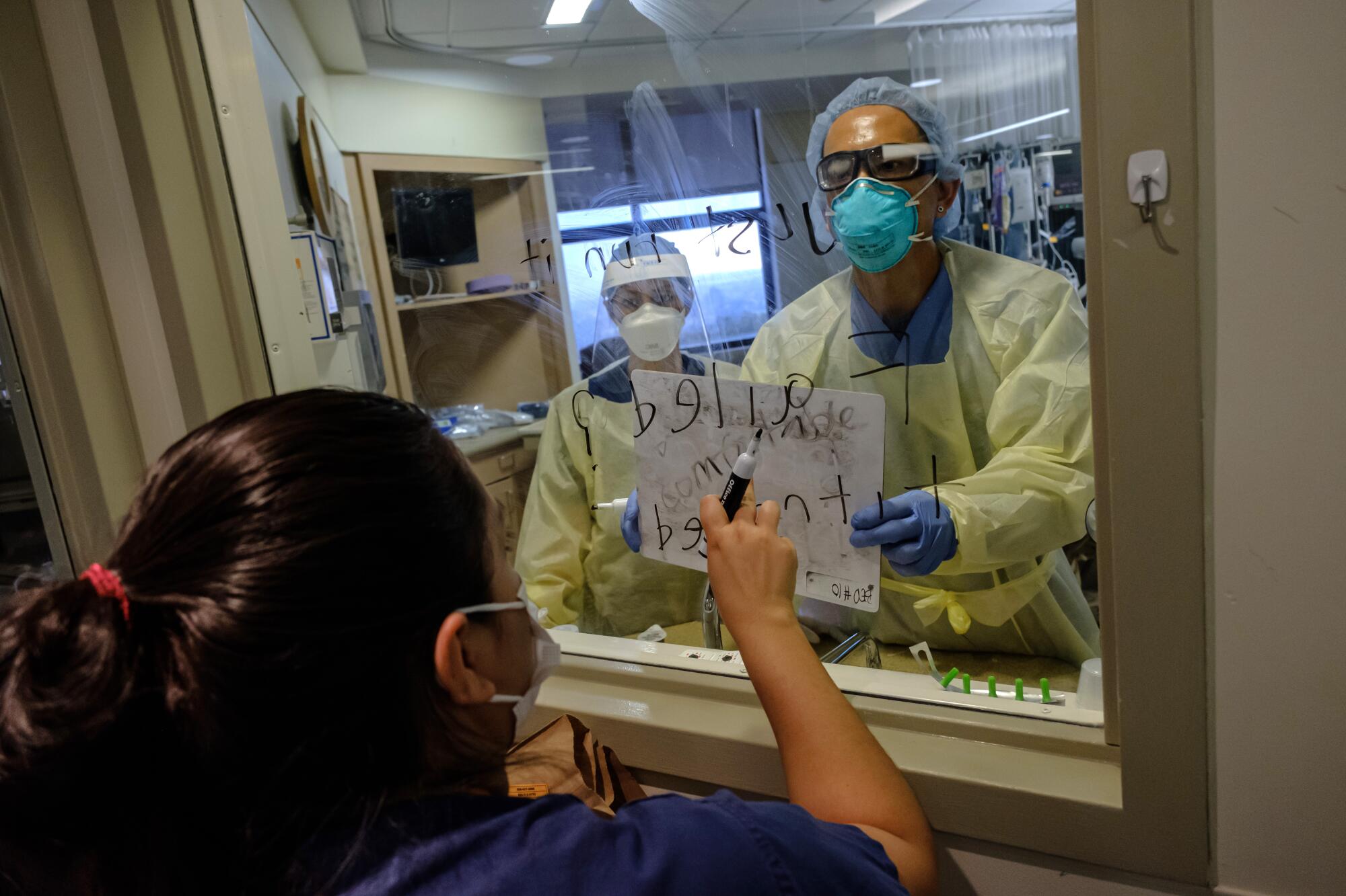 RN Reyna Gomez, left, communicates with Norah Pena and John Stanley