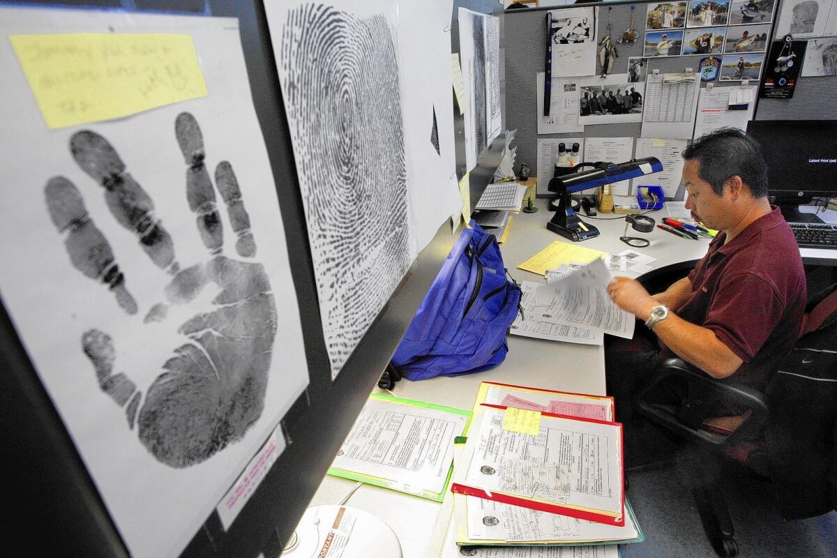Forensic print specialist Jimmy Wong analyzes fingerprints inside the LAPD's Latent Print Unit. Severe staffing shortages have worsened a backlog in fingerprint evidence.
