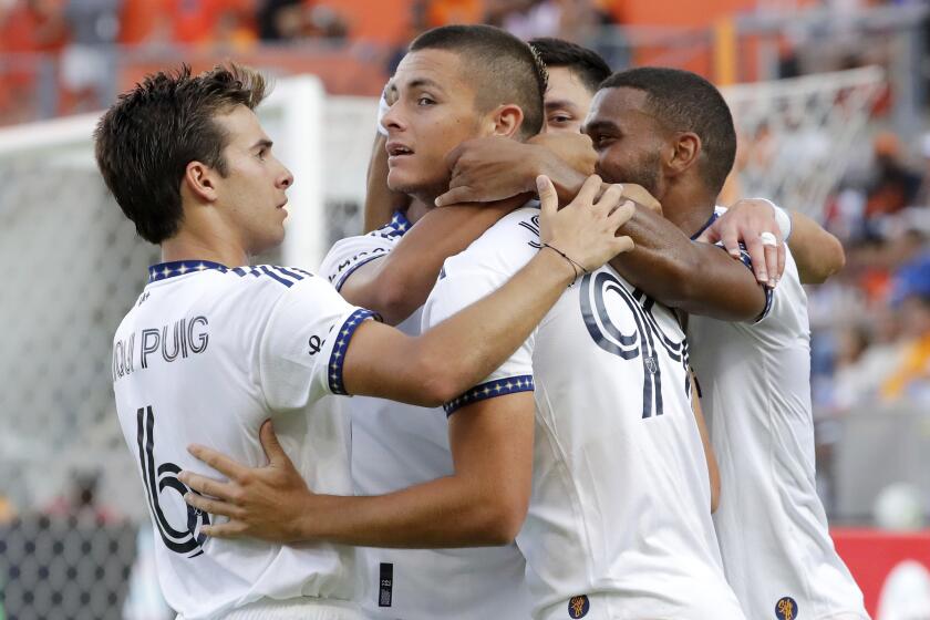 Los Angeles Galaxy forward Dejan Joveljic, center, is surrounded by teammates as they celebrate.