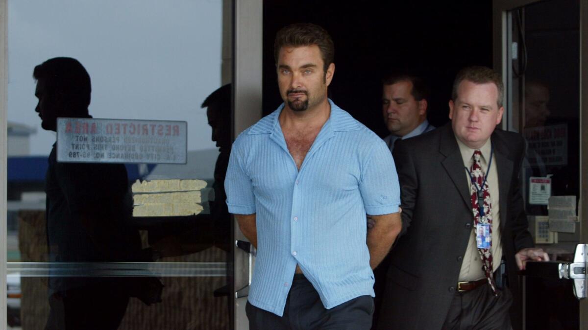 Fugitive rapist Andrew Luster is led out of the U.S. Customs building in June 2003 after arriving at LAX in federal custody. Luster was caught in Puerto Vallarta, Mexico. (Gina Ferazzi/Los Angeles Times)