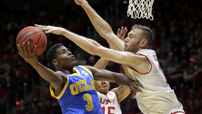 UCLA guard Aaron Holiday has his driving layup challenged by Utah forward David Collette during the first half Saturday.