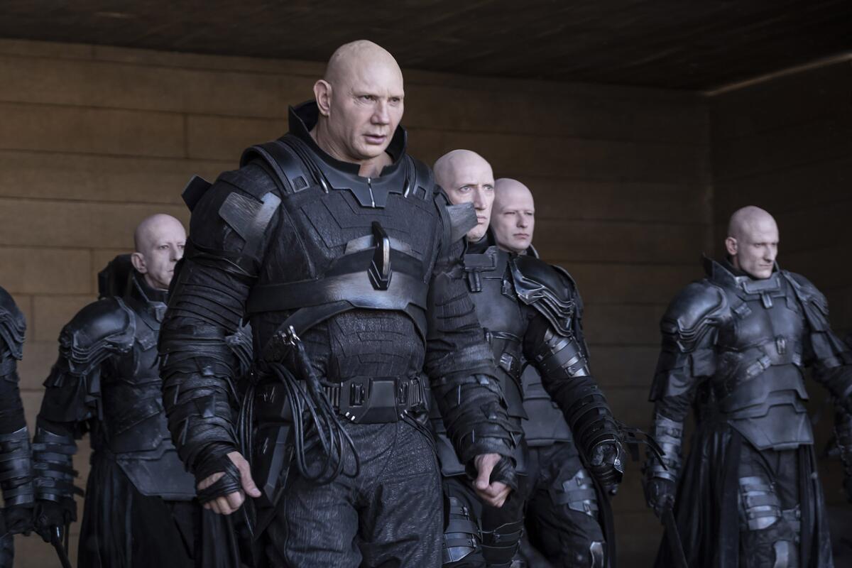 A group of bald, menacing men in black armor in the movie "Dune."