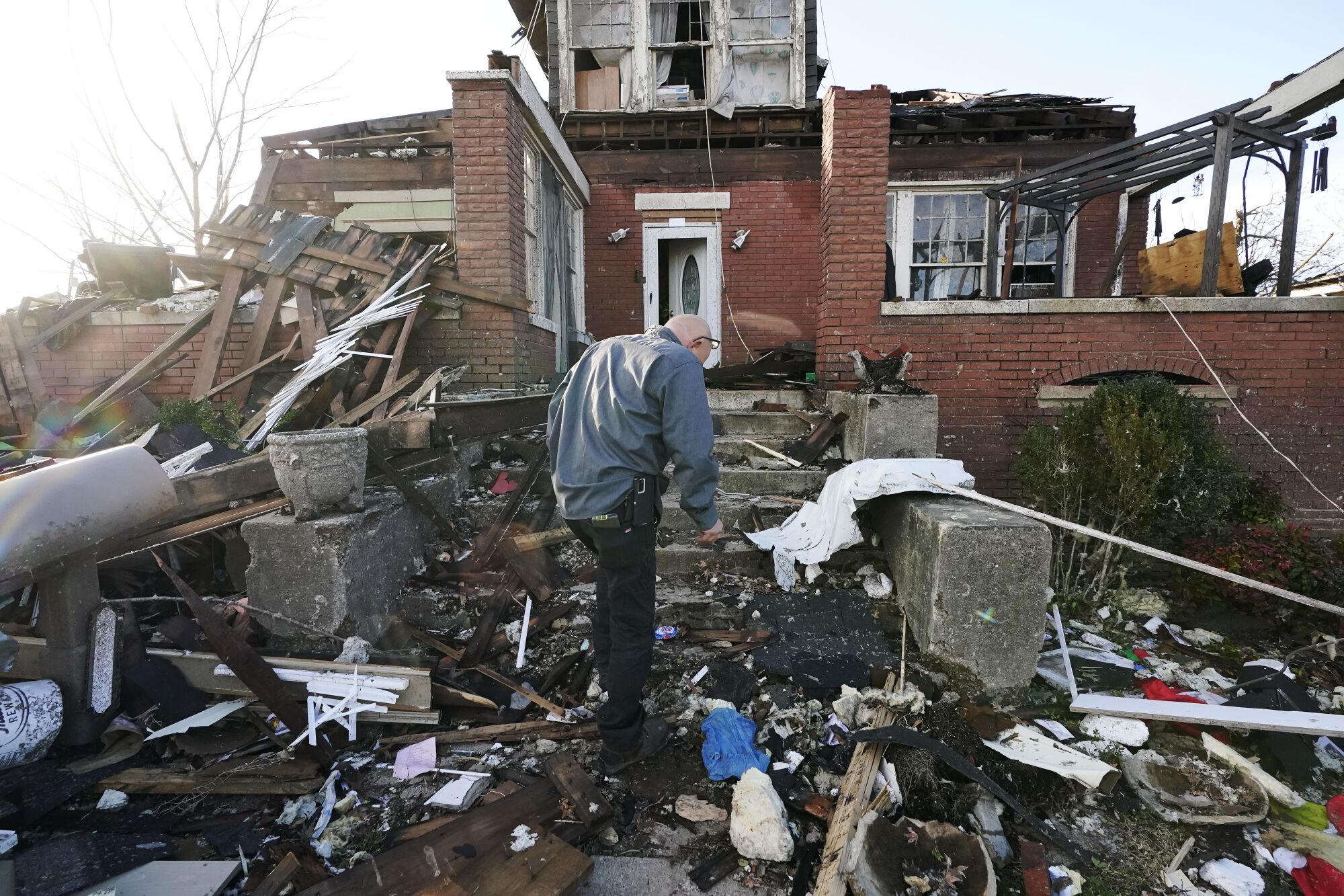 A man walks near his tornado-damaged home 