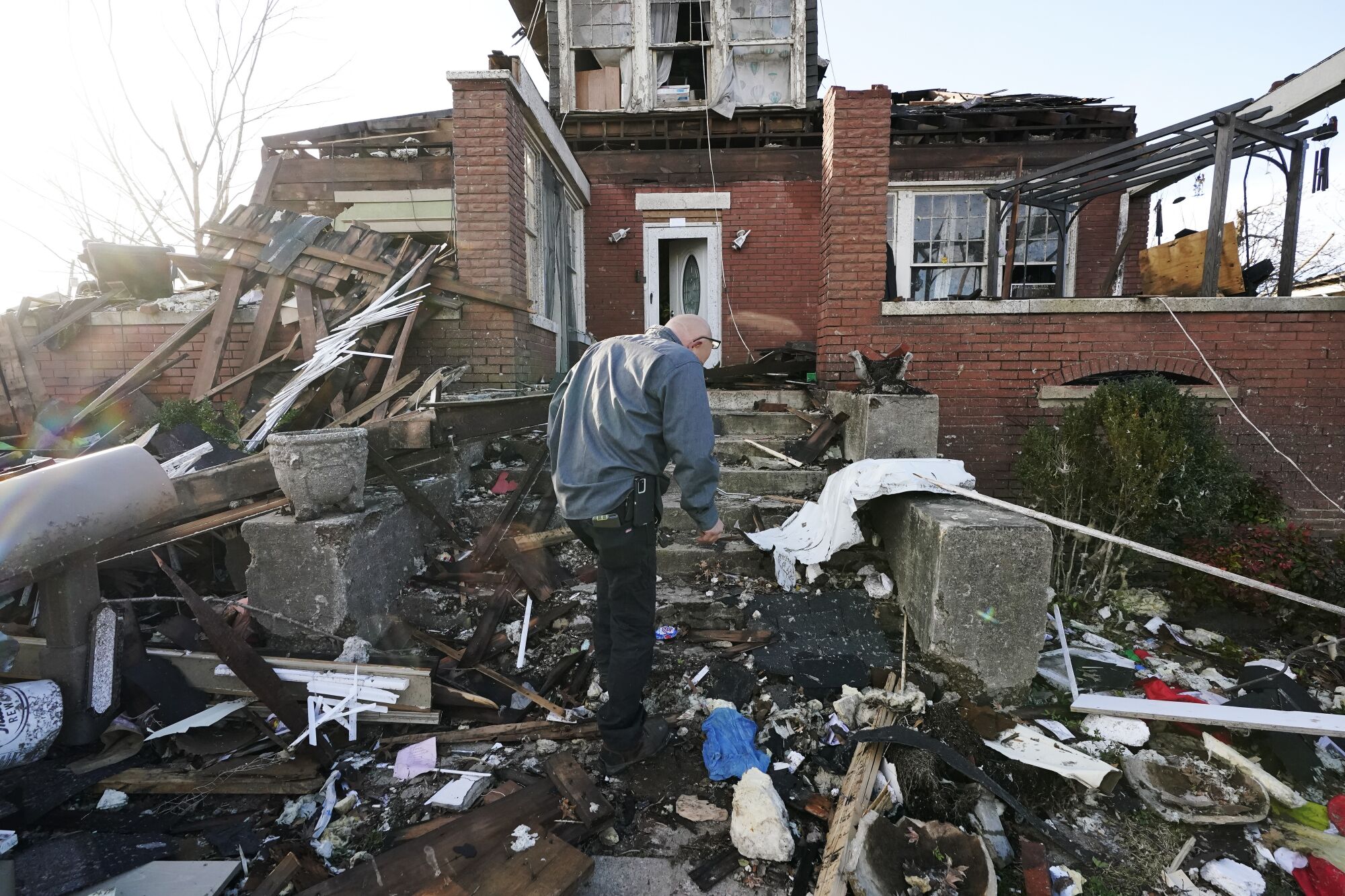 A man walks near his tornado-damaged home