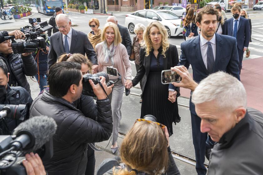 Theranos founder and CEO Elizabeth Holmes, center, walks into federal court with her partner Billy Evans, right, and her parents in San Jose, Calif., Friday, Nov. 18, 2022. A federal judge will decide whether Holmes should serve a lengthy prison sentence for duping investors and endangering patients while peddling a bogus blood-testing technology. (AP Photo/Nic Coury)