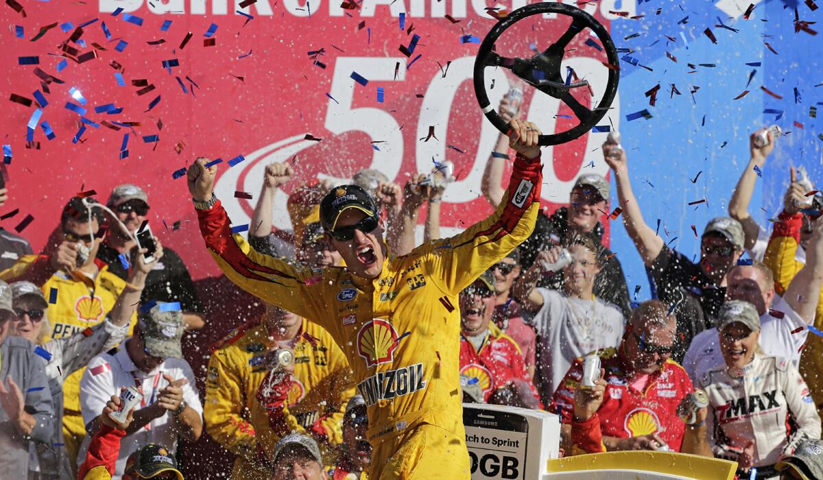 Joey Logano celebrates after winning the NASCAR Sprint Cup series auto race at Charlotte Motor Speedway on Sunday.