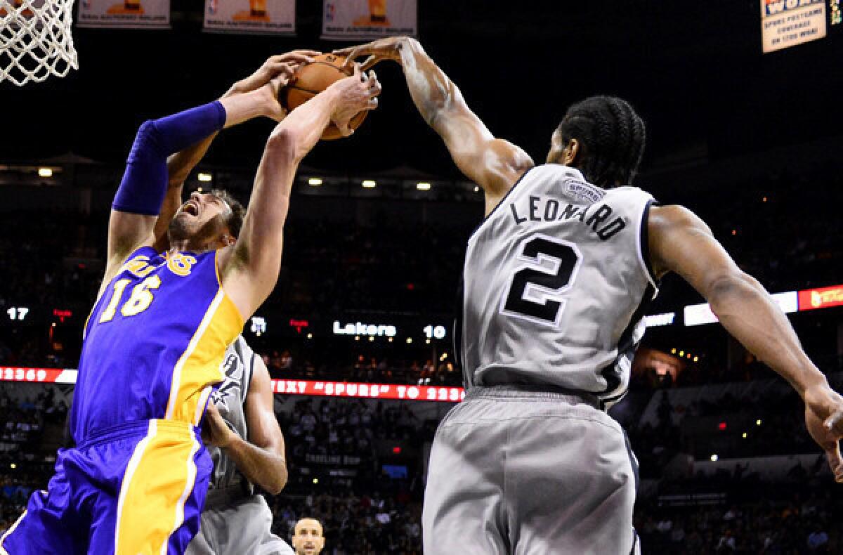 Lakers power forward Pau Gasol has his shot blocked trying to score against Spurs forward Kawhi Leonard and power forward Tim Duncan.