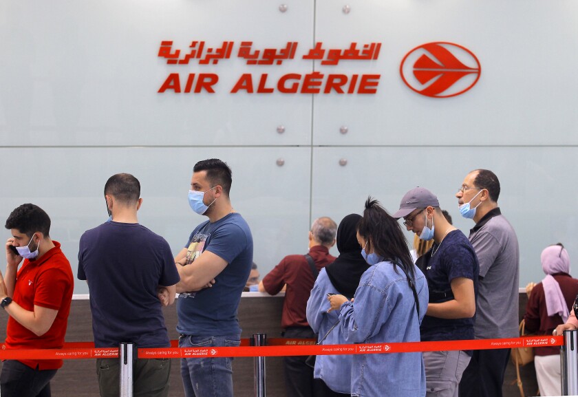 Travelers queue at the Houari Boumediene airport for a flight bound to Paris, Tuesday, June 1, 2021 in Algiers. Algeria has partially reopened its air borders Tuesday for the first time in over 15 months of the COVID-19 crisis. (AP Photo/Fateh Guidoum)