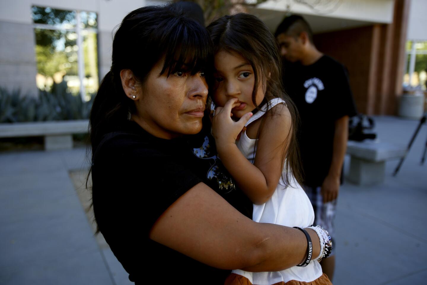 A tearful Martha Castaneda, aunt of Armando Villa, holds her daughter Naomi Castaneda, 3, at a news conference at Cal State Northridge. University officials announced Friday that the fraternity has closed.