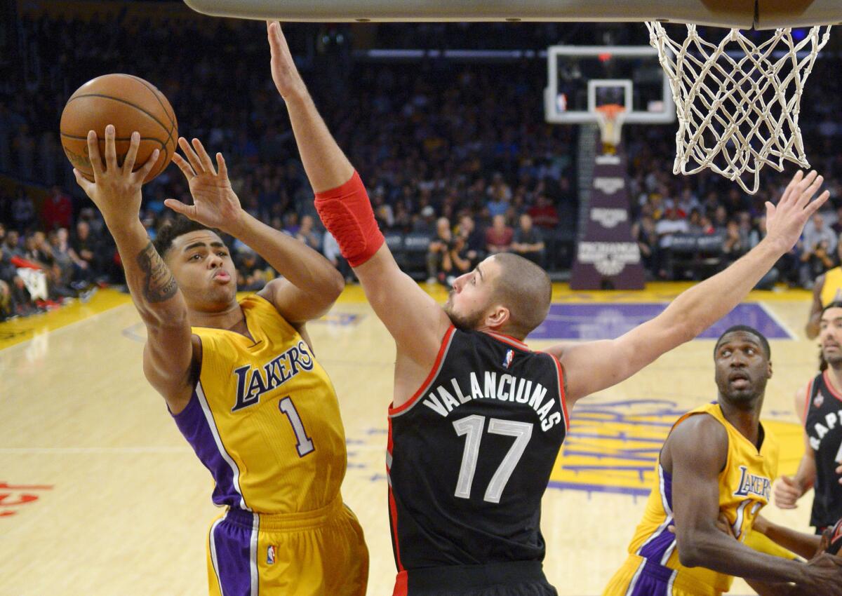 Lakers guard D'Angelo Russell, left, shoots as Toronto center Jonas Valanciunas defends on Friday night.