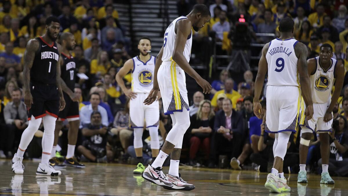 Golden State Warriors' Kevin Durant, center, limps off the court during the second half of Game 5 of the team's second-round NBA playoff series against the Houston Rockets on Wednesday in Oakland.