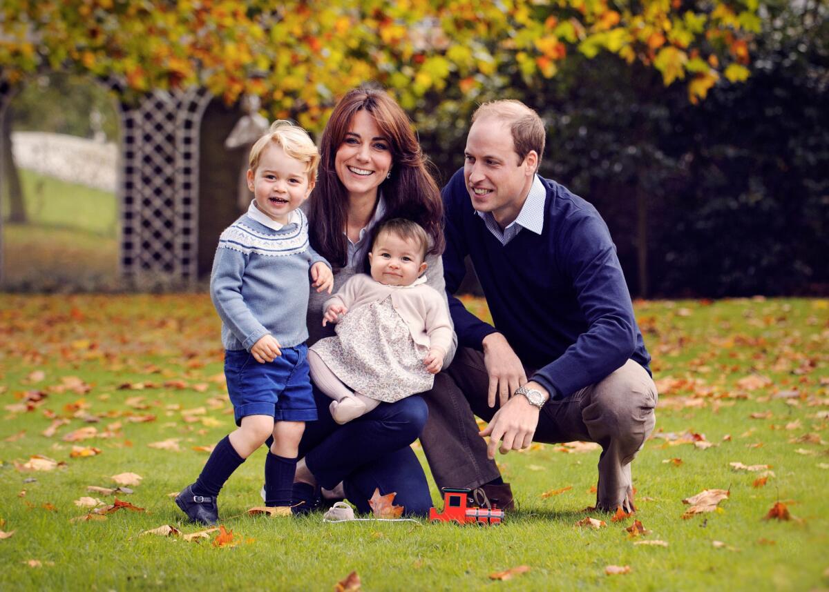 Britain's Prince William, right, and Catherine, Duchess of Cambridge and their two children, Prince George and Princess Charlotte, pose for a photograph taken in late October at Kensington Palace in London.