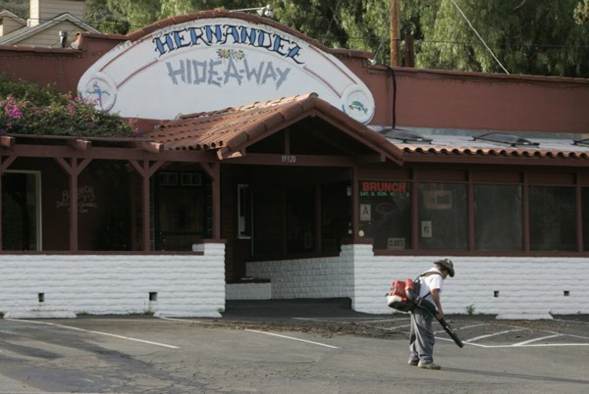 A gardener clears leaves from the parking lot of Hernandez Hideaway in Escondido in 2010.