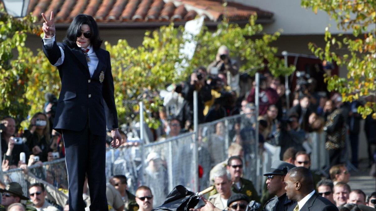 Michael Jackson gives the peace sign to supporters while standing on top of the SUV he left Santa Maria Court in. Jackson was arraigned on child molestation charges in 2004.