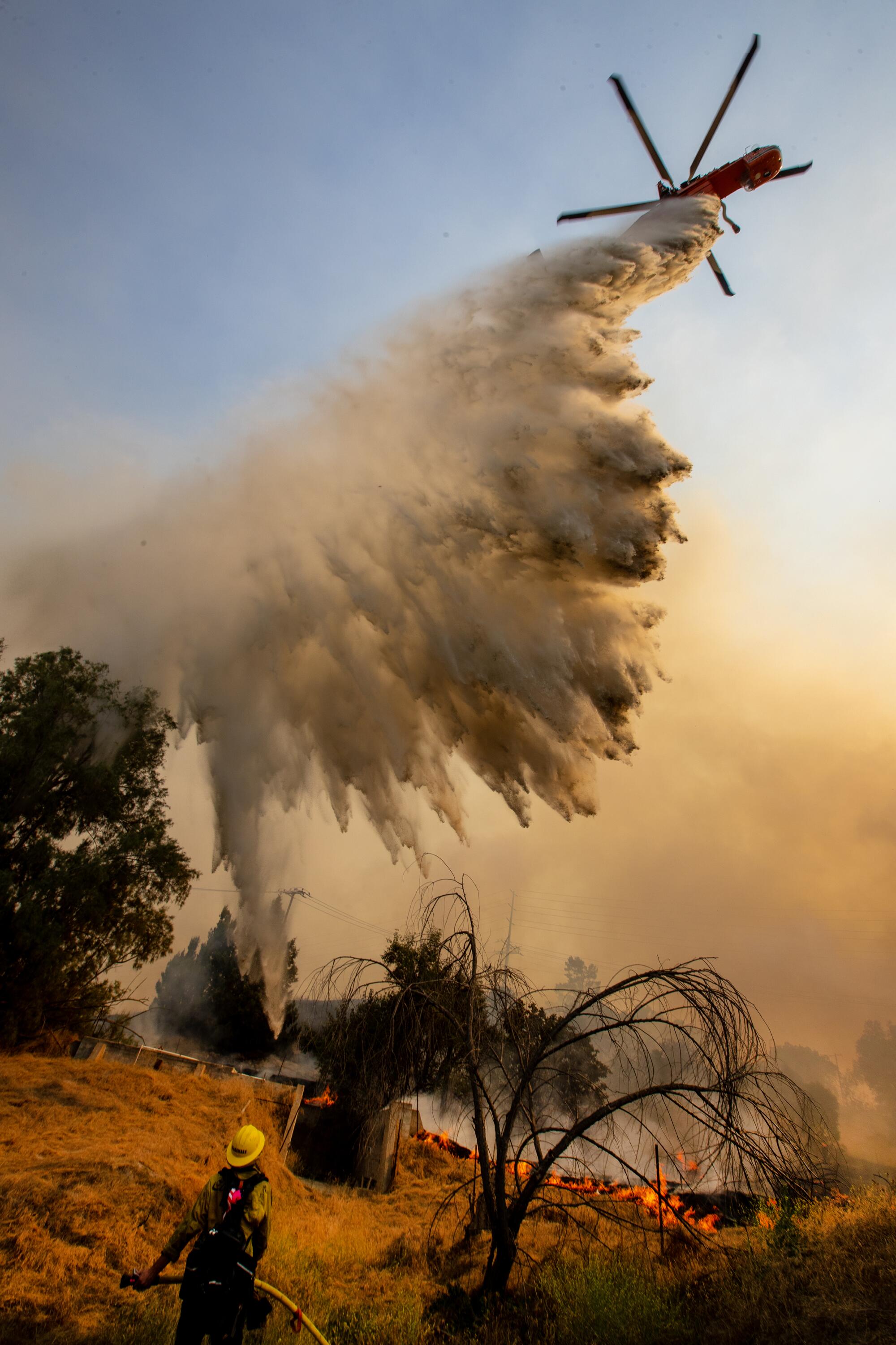 An air tanker drops fire retardant ahead of burning brush.