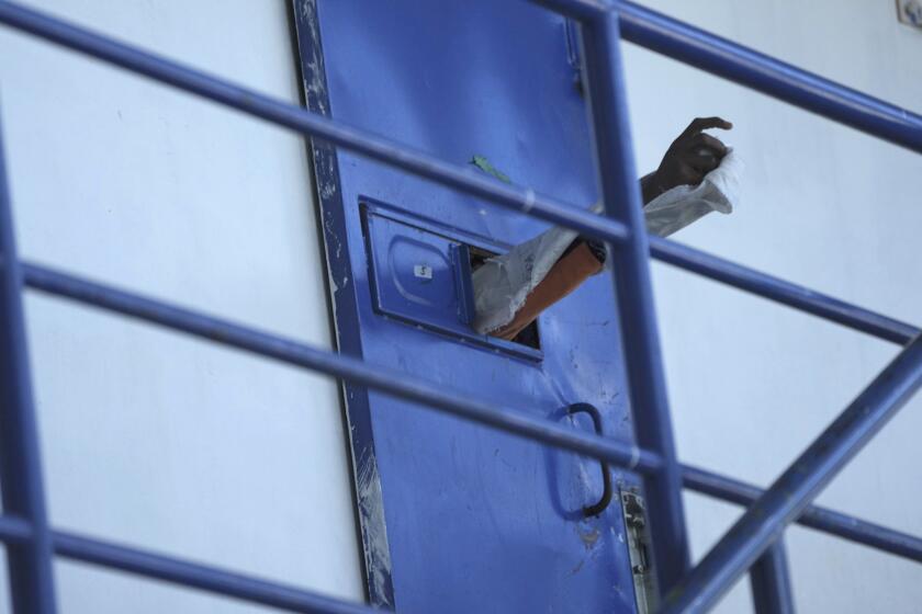 Un reo saca su brazo a través de la puerta de su celda en la cárcel de Cotopaxi, mientras los militares realizan un recorrido con la prensa por el centro penitenciario, en Latacunga, Ecuador, el jueves 22 de febrero de 2024. Según las fuerzas armadas, la visita con invitación a los medios permite mostrar que se ha recuperado el control dentro de las prisiones del país. (AP Foto/Dolores Ochoa)