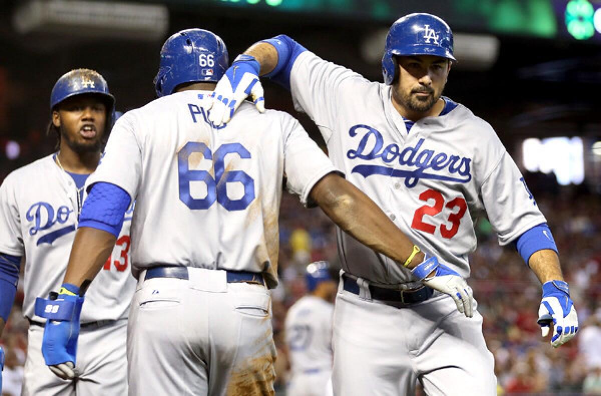 Dodgers first baseman Adrian Gonzalez (23) celebrates with teammates Yasiel Puig (66) and Hanley Ramirez after hitting a three-run home run against the Diamondbacks in the fourth inning Sunday afternoon in Phoenix.