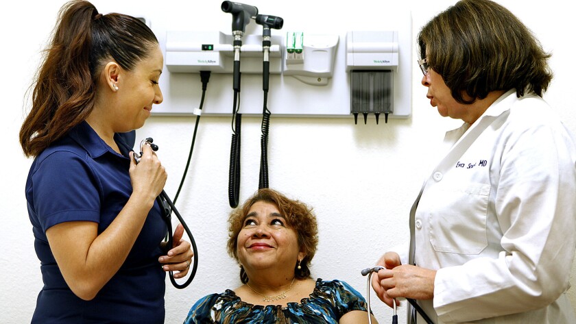 Rosa Segovia, 59, is seen by health coach Veronica Jaime, left, and Dr. Eva Snow at the Culinary Extra Clinic.