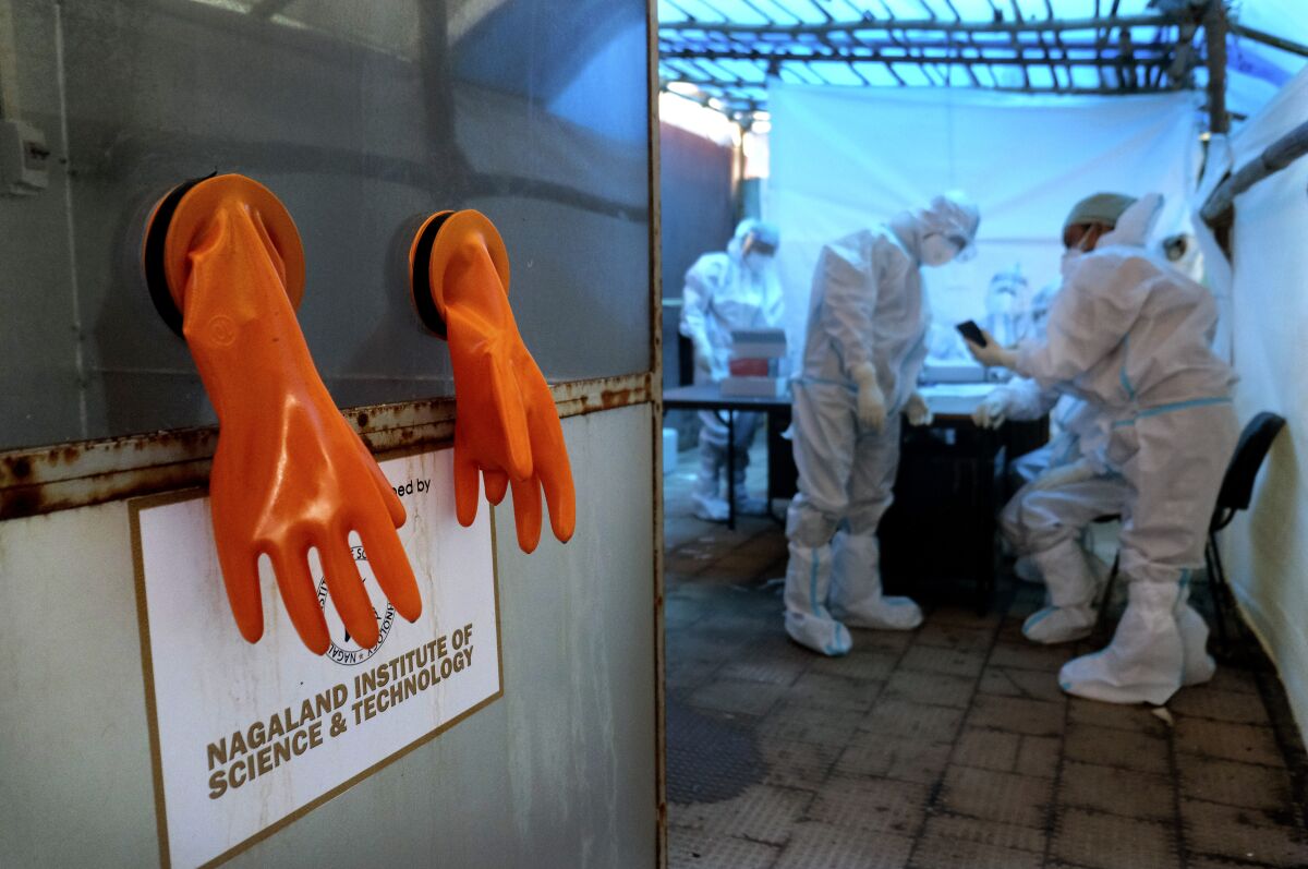 A pair of protective gloves hang by the testing booth, as health workers prepare for the day at a COVID-19 testing center in Kohima, capital of the northeastern Indian state of Nagaland, Saturday, Oct. 10, 2020. India’s total coronavirus positive cases near 7 million with another 73,272 infections reported in the past 24 hours. The Health Ministry on Saturday put the total positive caseload at 6.97 million, second to 7.66 million infections registered in the worst-hit United States. (AP Photo/Yirmiyan Arthur)