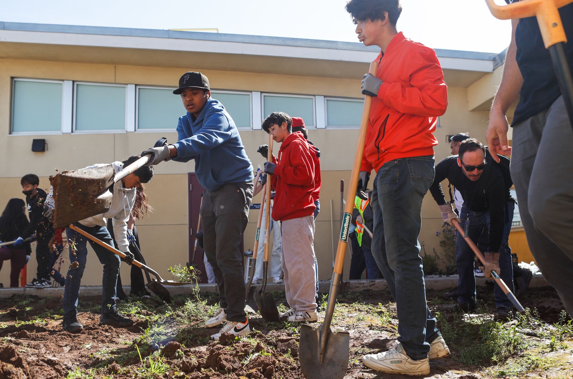 Southwest Middle School student Oliver Bennett, 14, left, and classmates work to create a community garden