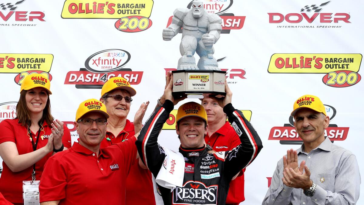 NASCAR driver Erik Jones celebrates with the trophy in Victory Lane after winning the Xfinity Series Ollie's Bargain Outlet 200 at Dover International Speedway on Saturday.