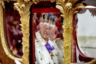 Britain's King Charles III greets the crowd as he and Queen Camilla travel to Buckingham Palace in the Gold State Coach after their coronation ceremony in Westminster Abbey, in London, Saturday, May 6, 2023. (Rob Pinney/Pool Photo via AP)