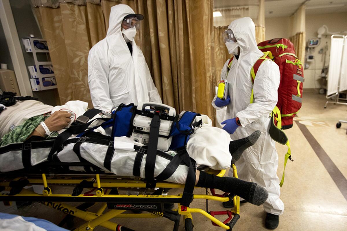 Medical personnel in protective gear and a patient 