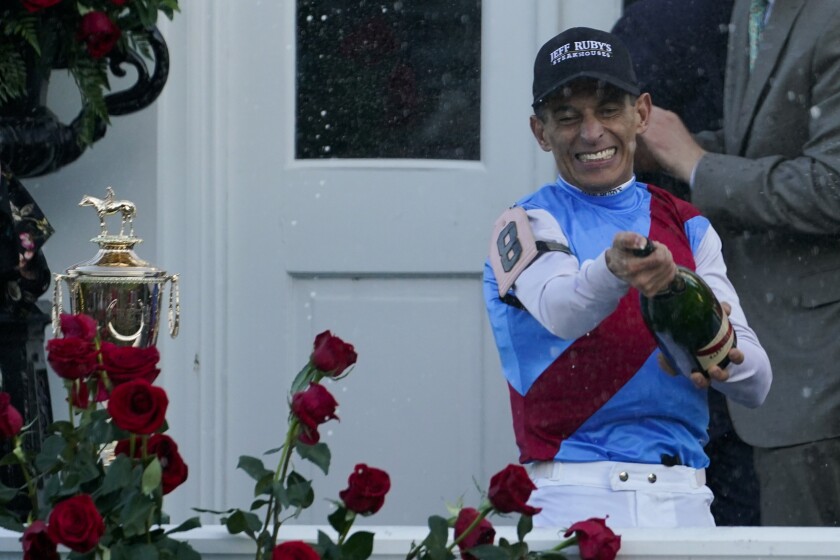Jockey John Velazquez sprays champagne after winning the 147th running of the Kentucky Derby on Medina Spirit at Churchill Downs, Saturday, May 1, 2021, in Louisville, Ky. (AP Photo/Brynn Anderson)