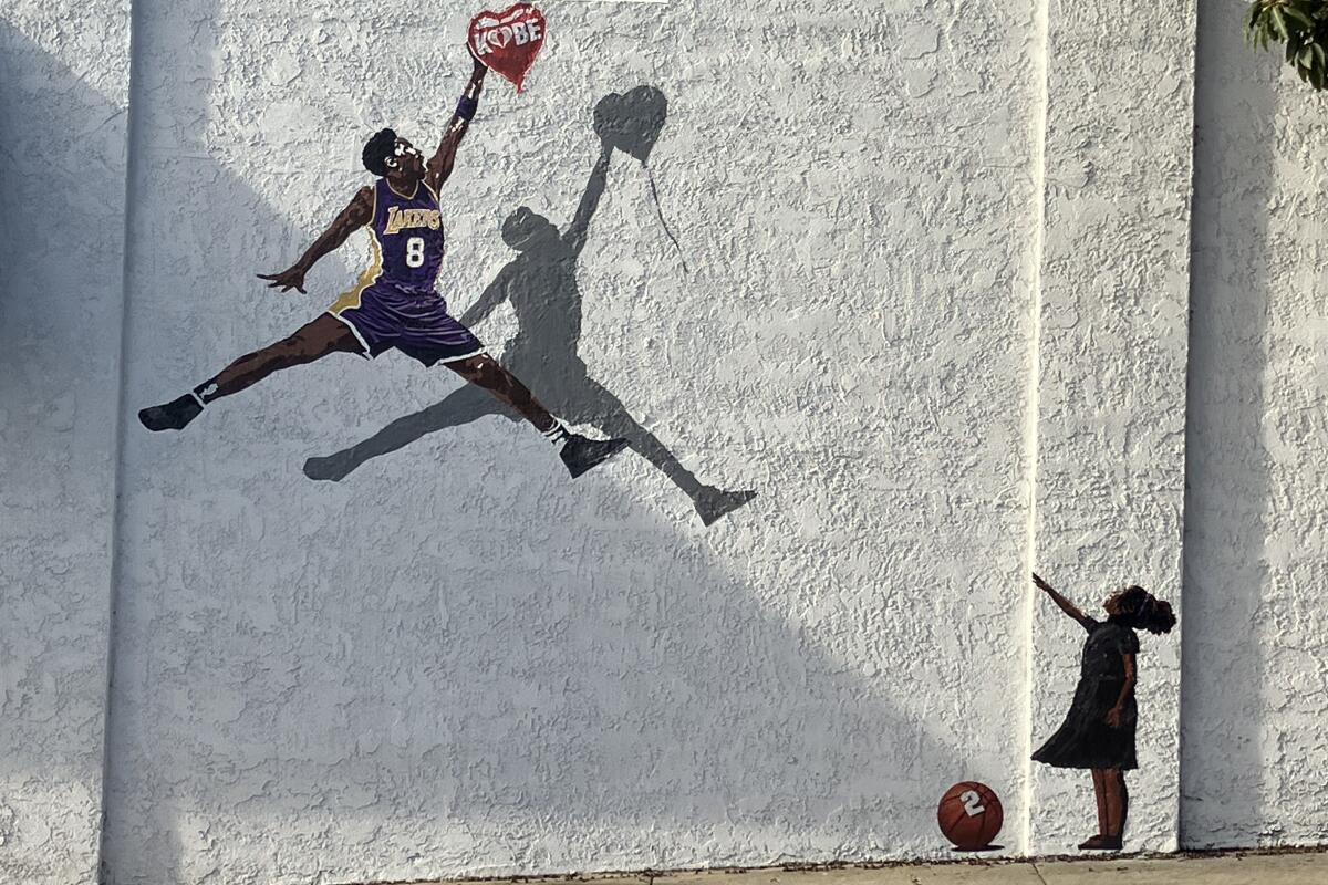 A mural in Laguna Beach shows Kobe Bryant in the air and Gianna Bryant pointing at him to get a balloon.