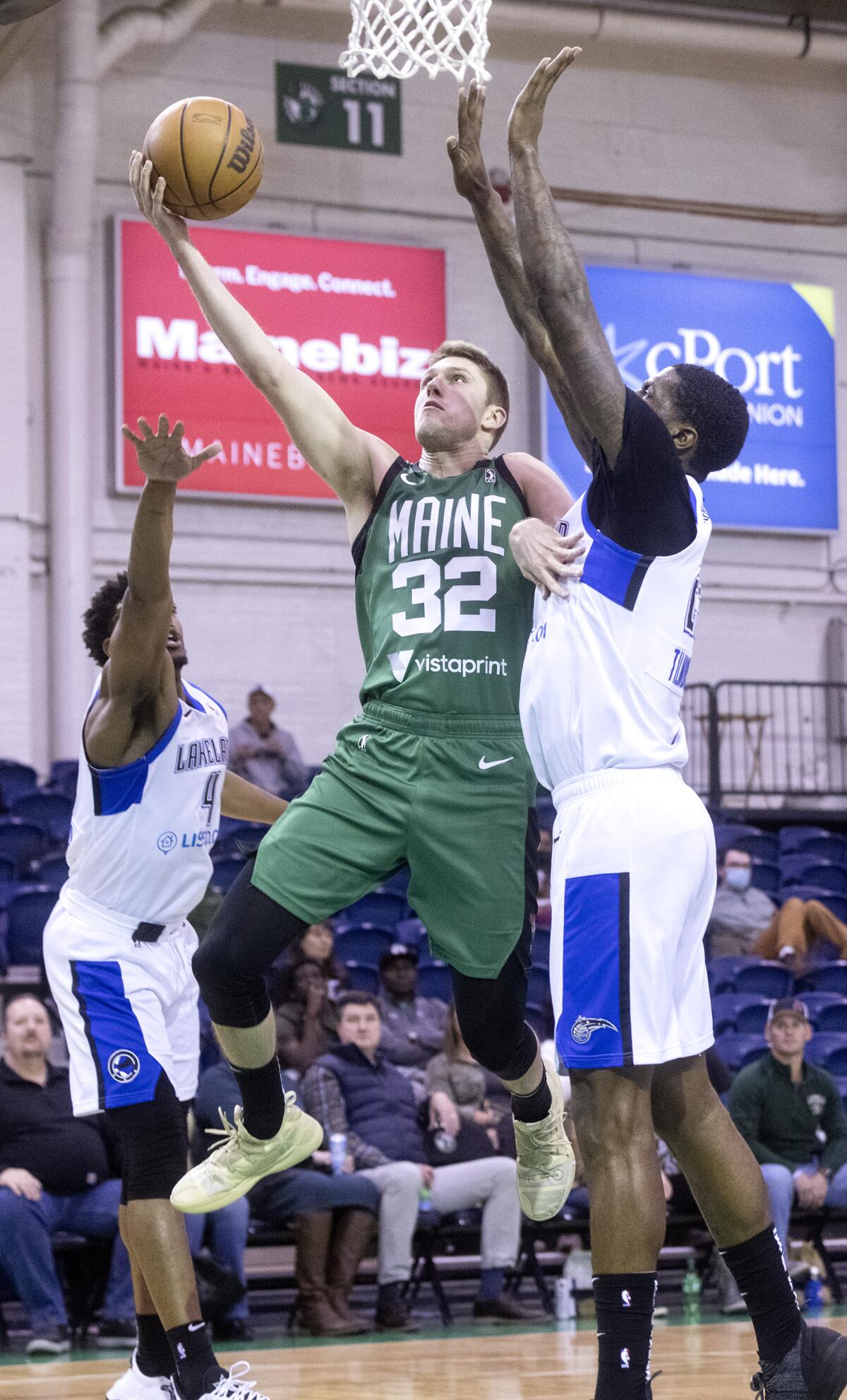 Matt Ryan (32) elevates between two defenders for a layup while playing for the G League's Maine Celtics last season.