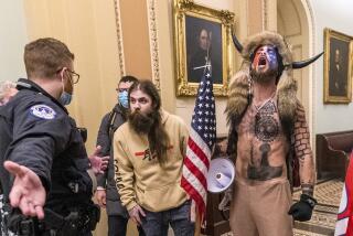 FILE - In this Jan. 6, 2021 file photo, supporters of President Donald Trump, including Jacob Chansley, right with fur hat, are confronted by U.S. Capitol Police officers outside the Senate Chamber inside the Capitol in Washington. Many of those who stormed the Capitol on Jan. 6 cited falsehoods about the election, and now some of them are hoping their gullibility helps them in court. Albert Watkins, the St. Louis attorney representing Chansley, the so-called QAnon shaman, likened the process to brainwashing, or falling into the clutches of a cult. Repeated exposure to falsehood and incendiary rhetoric, Watkins said, ultimately overwhelmed his client's ability to discern reality. (AP Photo/Manuel Balce Ceneta, File)