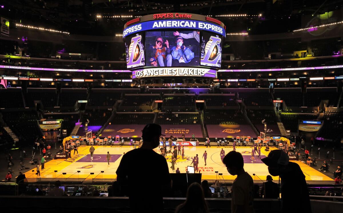 A family in the stands is silhouetted against the arena floor at Staples Center