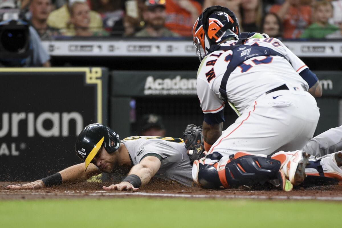 Oakland Athletics Chad Pinder, left, is tagged out at home by Houston Astros catcher Martin Maldonado, right, during the first inning of a baseball game, Tuesday, July 6, 2021, in Houston. (AP Photo/Eric Christian Smith)