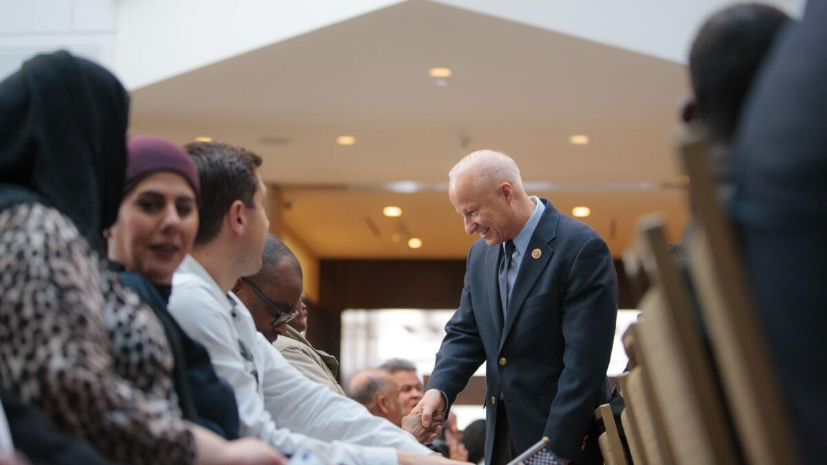 Rep. Mike Coffman (R-Colo.) talks with new U.S. citizens at a naturalization ceremony in Denver in February.